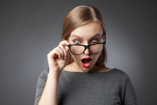 戴眼镜的大眼睛女人惊讶地往下看图片下载