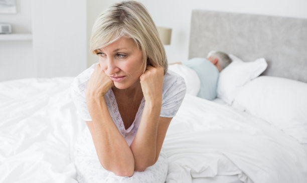 紧张的成熟女人坐在床上图片下载