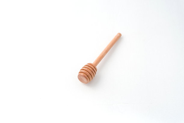 白色背景上木制的蜂蜜勺图片下载