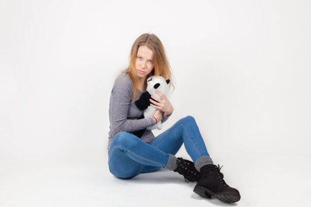 可爱的女孩坐在一个熊猫玩具图片下载