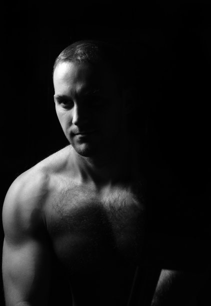肌肉男坐着的肖像。图片下载