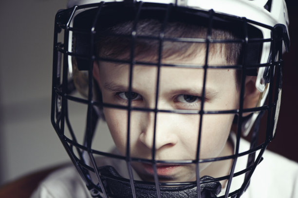 戴着冰球头盔的小男孩。情绪的孩子。图片下载