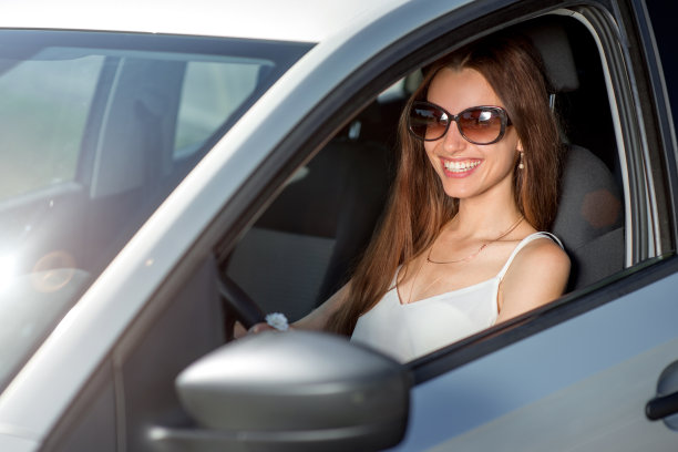 年轻微笑的女人开着她的新车图片下载