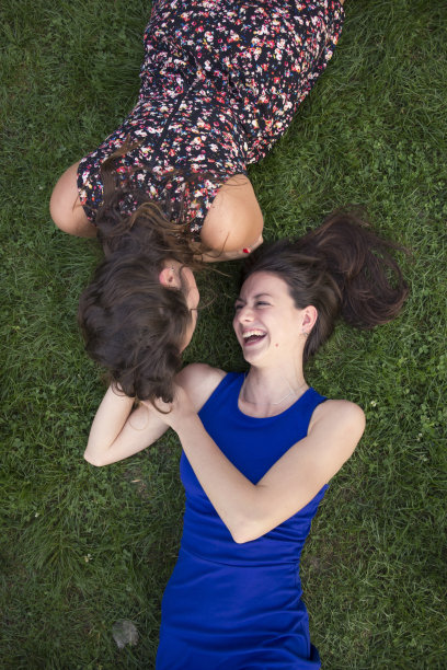 两个亲密可爱的女孩，在草地上放松。图片下载