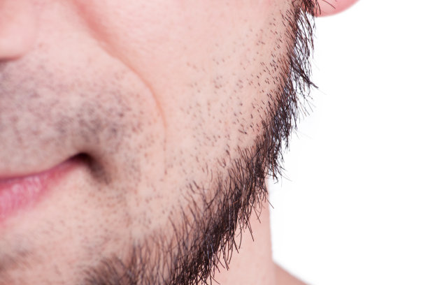 年轻的胡子男子站在灰色背景的特写图片下载