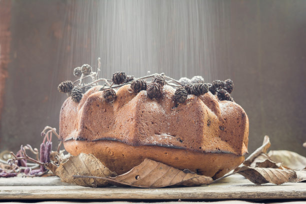 新鲜烘焙的甜蛋糕和飘落的糖霜图片下载