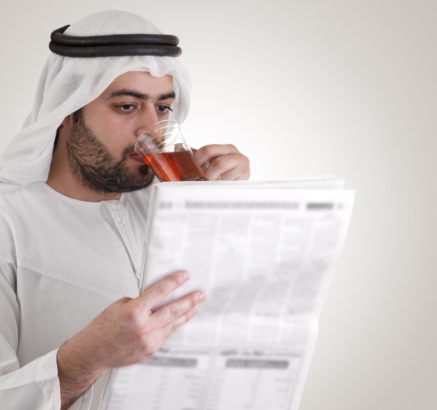 阅读报纸的阿拉伯商人图片下载