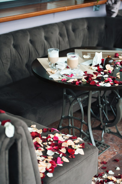 两杯咖啡放在撒满花瓣的桌子上。那家伙刚刚向他女朋友表白了图片下载