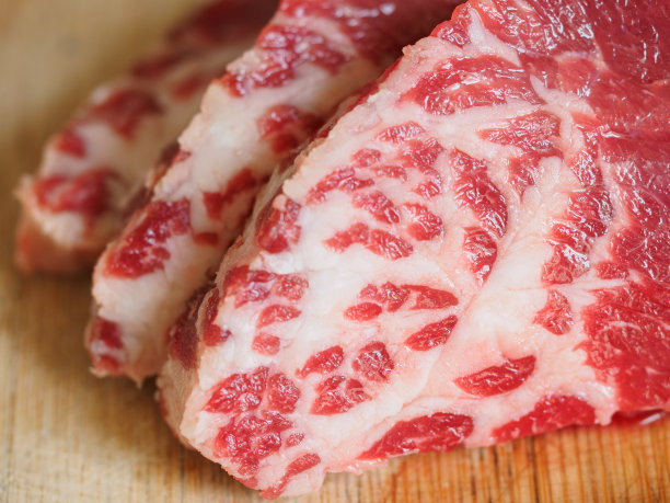 新鲜的生牛排放在木切板上，景深浅。图片下载