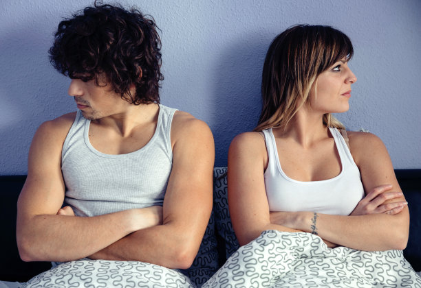 一对愤怒的夫妇双手交叉坐在床上图片下载