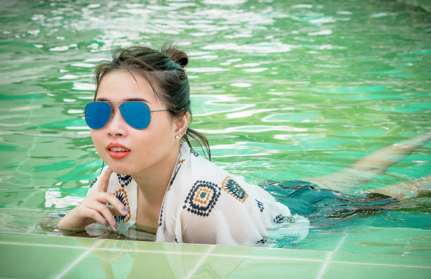 快乐美丽的年轻女子放松在游泳池图片下载