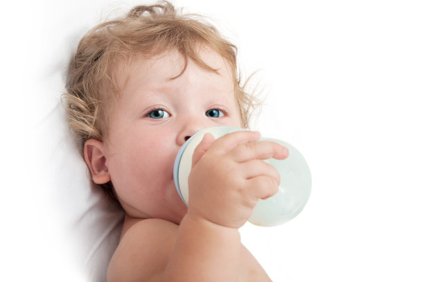 卷发的小婴儿吸着奶瓶图片下载