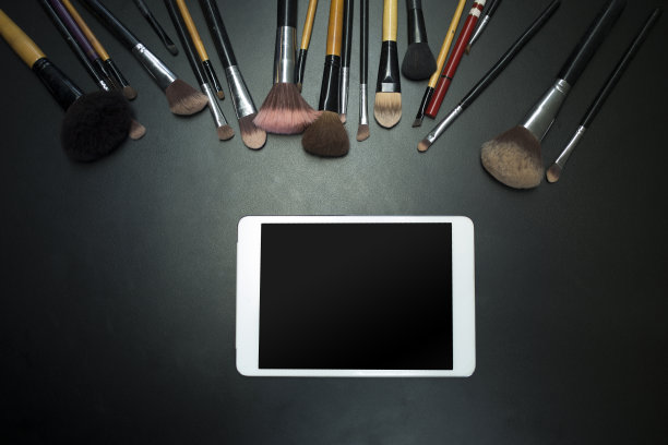 黑色背景上的化妆品和平板电脑图片下载