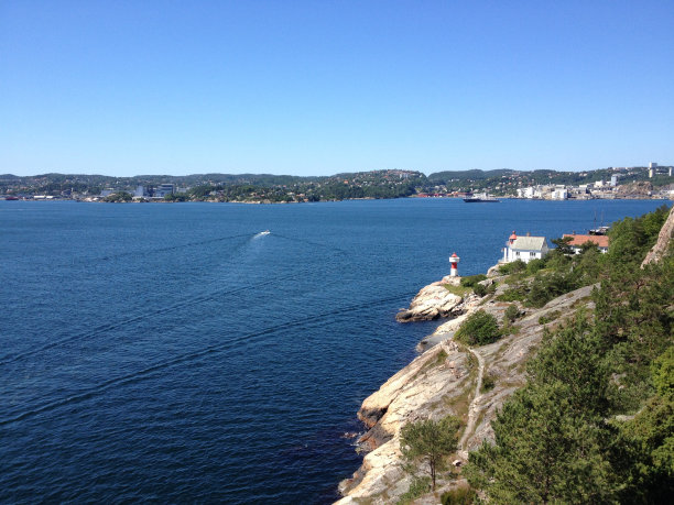 夏日里挪威克里斯蒂安桑的奥德罗亚灯塔。从山上俯瞰克里斯蒂安桑，下面是生机勃勃的蓝色大海。素材图片