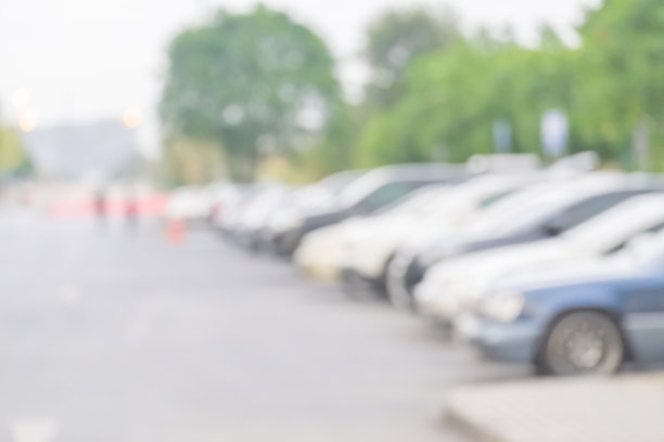 在官方场所模糊了室外停车场和炎热的太阳。汽车排成一排。模糊和抽象背景图片下载