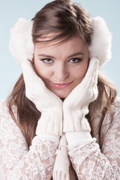 微笑可爱漂亮的女人女孩在耳套。图片下载