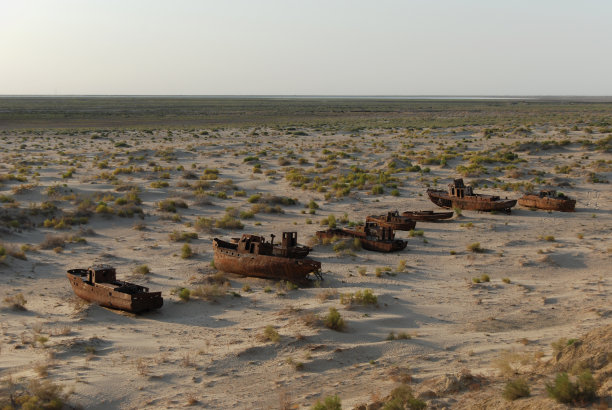 生锈的咸海渔船队躺在沙滩上图片下载