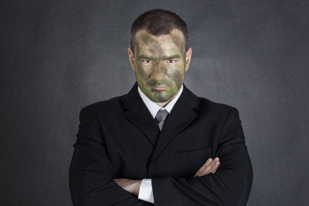 穿着丛林迷彩服，双臂交叉的严肃生意人图片下载