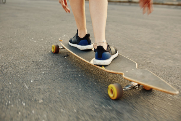 美丽的年轻女孩纹身骑长板在阳光灿烂的天气图片下载