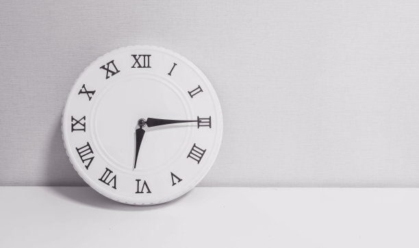 特写白色时钟装饰显示6点15分或早上6点15分在白色的木桌和壁纸纹理背景黑白色调与复制空间图片下载
