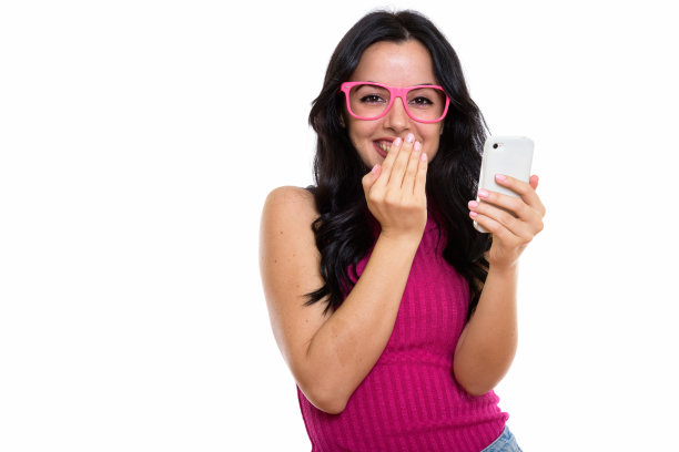 工作室拍摄的年轻快乐的西班牙女子微笑着，手里拿着手机，大笑图片下载