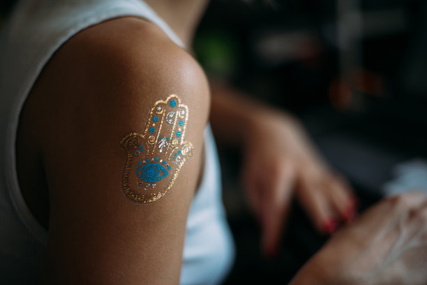 近距离的背影，漂亮的年轻女子在白色衬衫与临时纹身在她的手图片下载