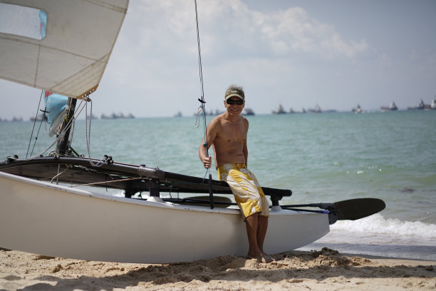 60多岁的亚洲退休老人和他的船合影图片下载