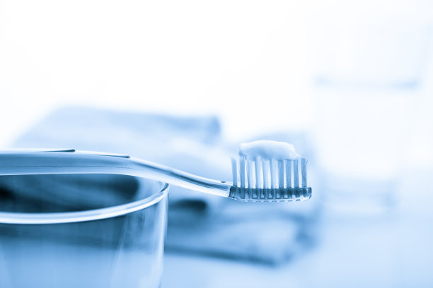 白色背景的玻璃材质的牙刷和牙膏图片下载