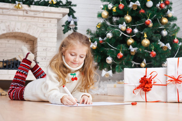 小女孩在圣诞树旁给圣诞老人写信图片下载