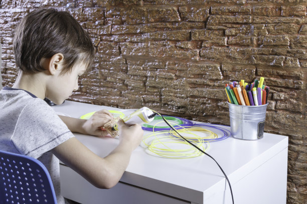 儿童使用3D打印笔。男孩在制造新物品。创意、科技、休闲、教育理念图片下载