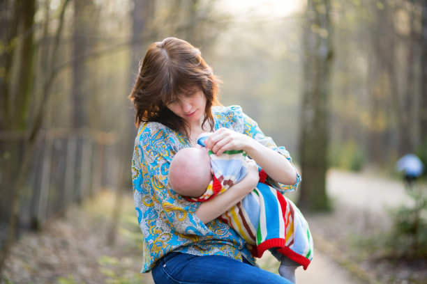 年轻的母亲和她的小婴儿在森林里图片下载