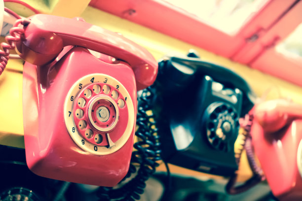 复古红色电话在靠近窗户背景的木桌上图片下载