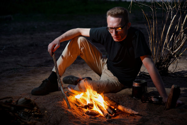 戴眼镜的疲惫男子在篝火旁图片下载