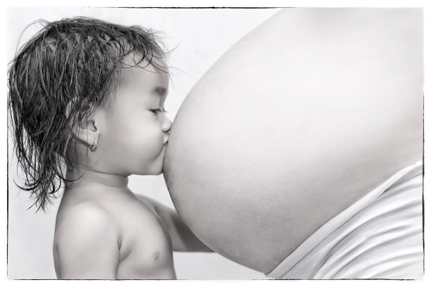 孩子亲吻妈妈的肚子图片下载