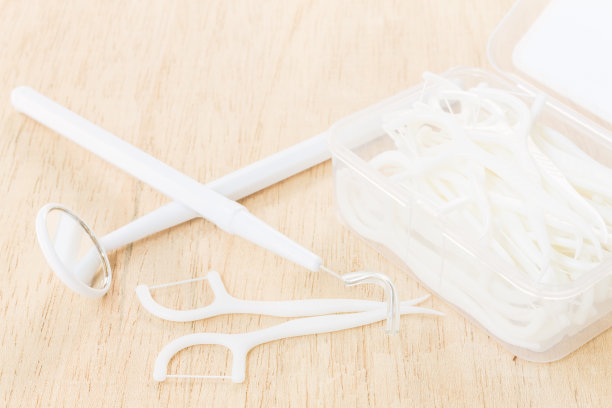 口腔用具:木制背景上的牙线图片下载