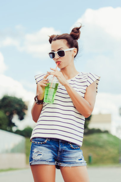 一个对着天空喝水的时髦女孩图片下载