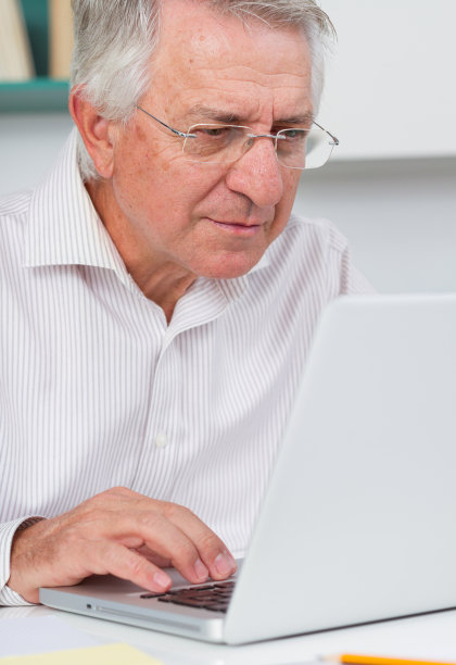 成熟的男人看起来在专注于她的笔记本电脑图片下载