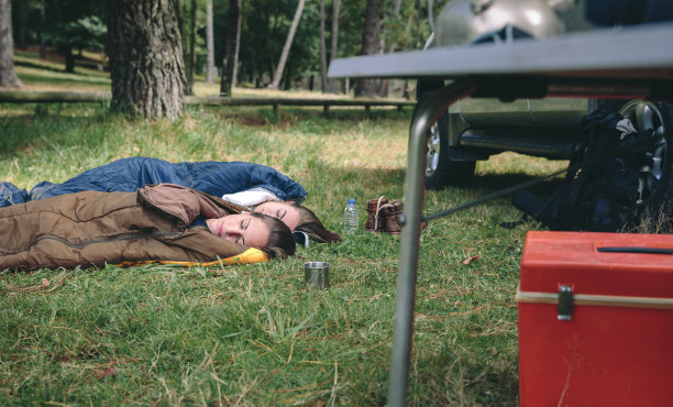 年轻女子在露营地的睡袋里休息图片下载