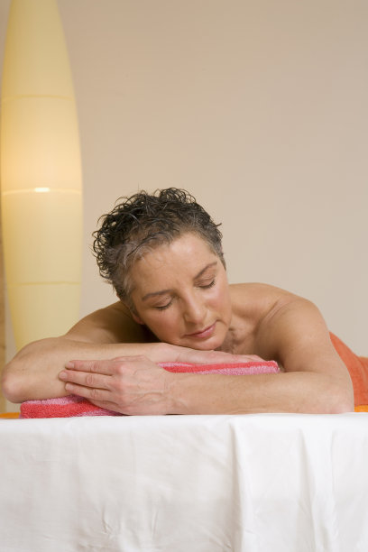 成熟的女人放松在按摩床上，闭着眼睛，肖像图片下载