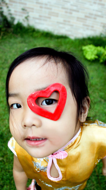 小女孩把红心贴在脸上图片下载