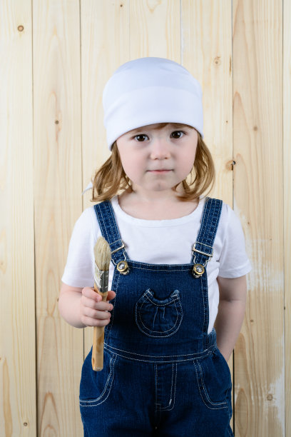 女孩拿着毛笔在木墙里摆姿势图片下载