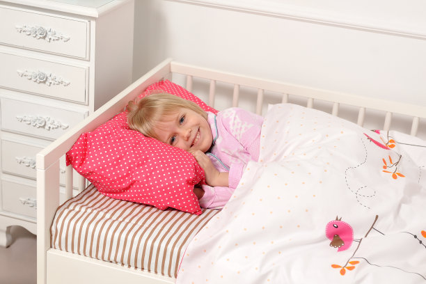 漂亮的小女孩睡在她的床上，然后醒来图片下载