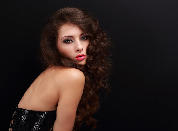 美丽的化妆女人与卷曲的棕色长发看图片下载