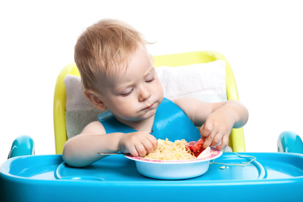 金发小男孩在吃意大利面图片下载