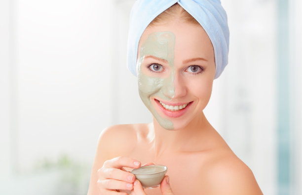 美丽的女孩在浴室和面膜面部皮肤护理图片下载