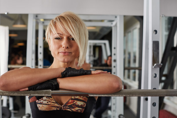 美丽的运动员金发女人摆姿势在权力机架图片下载