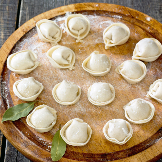 深色木桌上放着生饺子图片下载