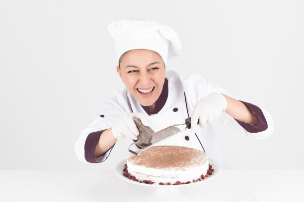 厨师与白帽子准备美味的巧克力奶油蛋糕whi图片下载