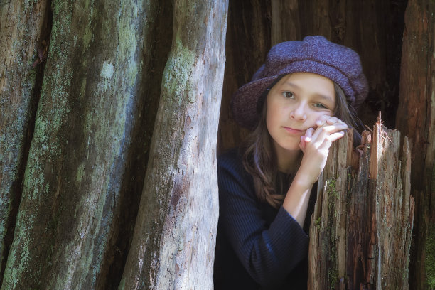 一个小女孩在空心树的特写图片下载