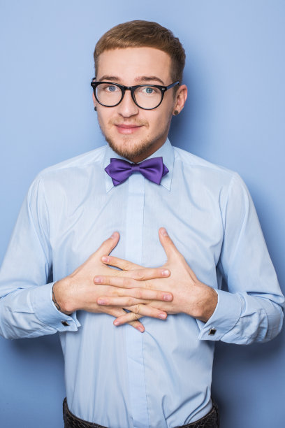 穿着蓝色衬衫，打着领结的谦逊的年轻人图片下载